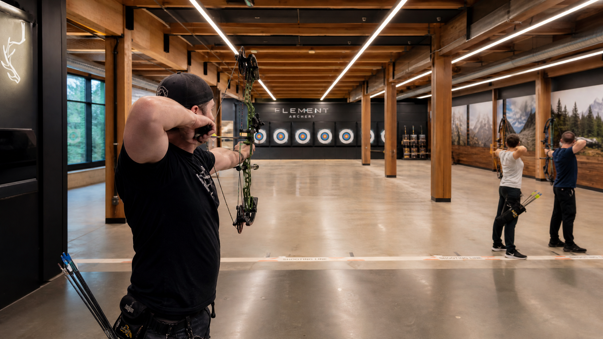 Sleek West Coast modern indoor archery range with exposed wood beams